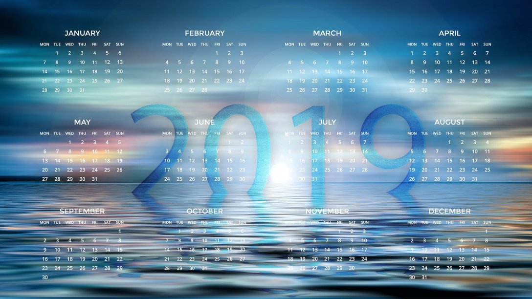 A stylized photo of water going off into the distance with the twelve months of 2019 overlaid it. 2019 can be seen at the horizon in the water.