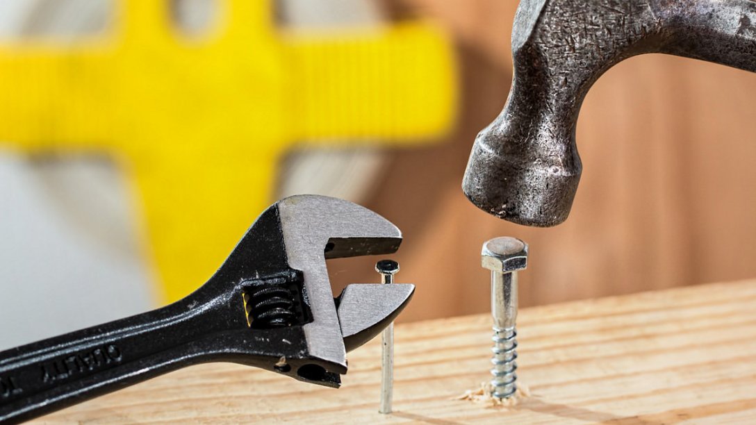 Tools being used in illogical ways. For example, someone is trying to use a wrench to put a nail into a piece of wood.
