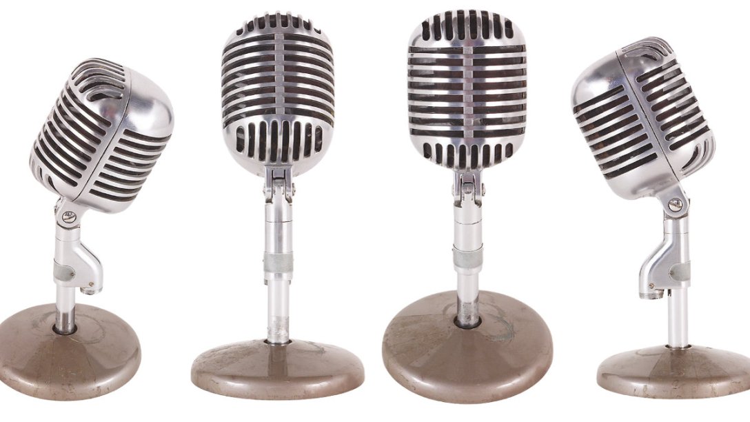 Four wireless microphones next to each other in a variety of orientations.